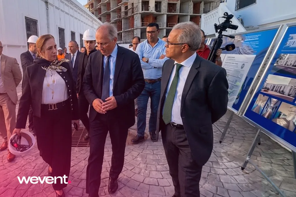 Visite officielle de chantier au Maroc : responsables institutionnels et caméra de presse devant les panneaux de présentation du projet