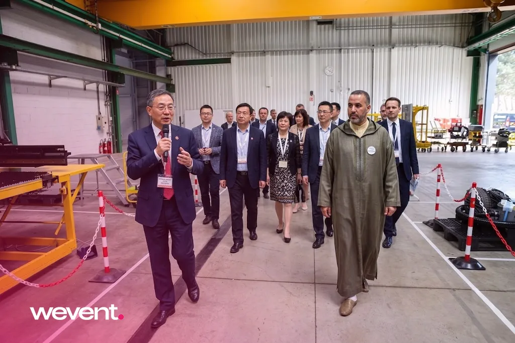 Visite inaugurale d'une usine au Maroc : délégation internationale guidée par un dirigeant dans un hall industriel lors d'un événement organisé par Wevent