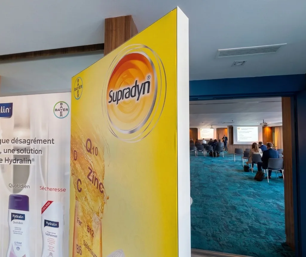 Stand Bayer Supradyn lors du congrès médical à Tanger avec salle de conférence en arrière-plan