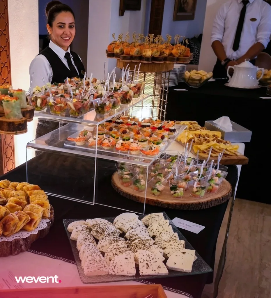 Serveuse devant buffet de verrines et bouchées événementielles